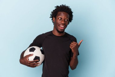Amerikan futbolu oynayan genç Afro-Amerikalı adam mavi arka planda izole edilmiş başparmak uzakta, gülerek ve kaygısızca.