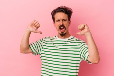 Pembe arka planda izole edilmiş genç beyaz adam gururlu ve kendinden emin hissediyor, örnek olarak.