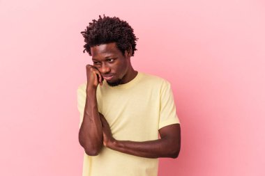 Genç Afrikalı Amerikalı, pembe arka planda izole edilmiş üzgün ve dalgın bir şekilde fotokopi odasına bakıyor..