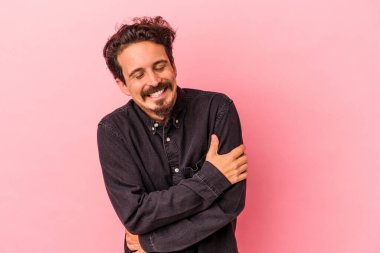 Genç beyaz adam pembe arka planda izole edilmiş gülüyor ve eğleniyor..