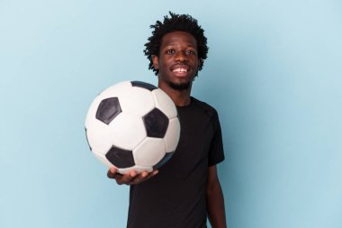 Genç Afro-Amerikan futbol oynayan adam mavi arka planda izole edilmiş.
