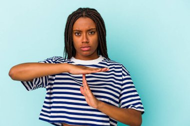 Genç Afrikalı Amerikalı bir kadın mavi arka planda izole edilmiş..