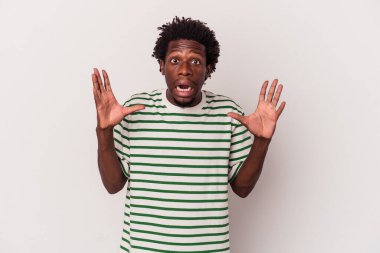 Genç Afrikalı Amerikalı adam beyaz arka planda izole edilmiş gökyüzüne haykırıyor, yukarı bakıyor, hayal kırıklığına uğramış..