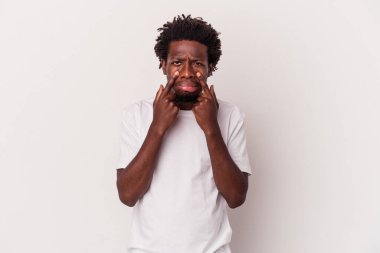 Beyaz arka planda izole edilmiş genç Afrikalı Amerikalı bir adam ağlıyor, bir şeyden memnun değil, ıstırap ve kafa karışıklığı konsepti..