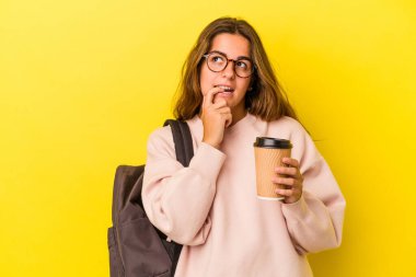 Sarı arka planda izole edilmiş kahve tutan beyaz bir kadın. Bir şeyin fotokopi odasına baktığını düşünerek rahatlamış..