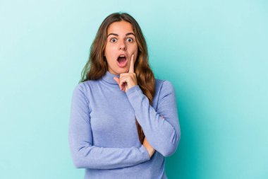 Kafkasyalı genç bir kadın mavi arka planda izole edilmiş. Harika bir fikri var, yaratıcılık kavramı..