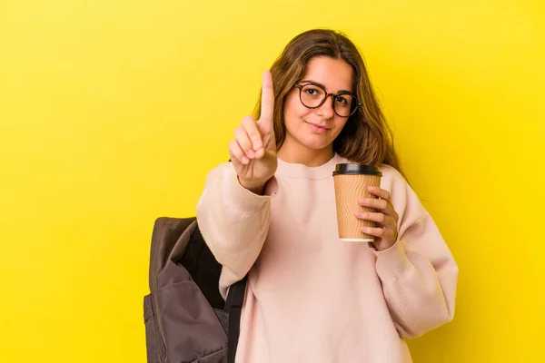 年轻的高加索女学生拿着黄色背景的咖啡 带着第一指尖 — 图库照片