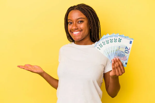 Mladá Africká Američanka Drží Bankovky Izolované Žlutém Pozadí Zobrazující Kopírovací — Stock fotografie