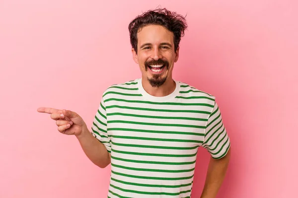 Joven Hombre Caucásico Aislado Sobre Fondo Rosa Sonriendo Alegremente Señalando —  Fotos de Stock