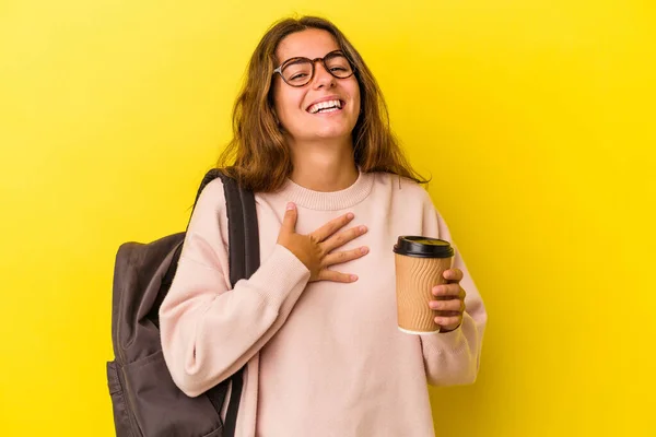 Joven Estudiante Caucásica Sosteniendo Café Aislado Sobre Fondo Amarillo Ríe — Foto de Stock