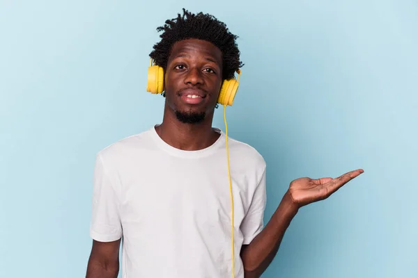 Young African American Man Listening Music Isolated Blue Background Showing — ストック写真