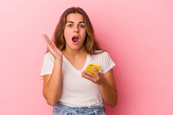 Ung Kaukasiska Kvinna Som Använder Mobiltelefon Isolerad Rosa Bakgrund Förvånad — Stockfoto