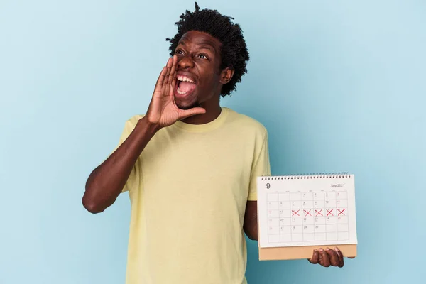 Jonge Afro Amerikaanse Man Houdt Kalender Geïsoleerd Blauwe Achtergrond Schreeuwen — Stockfoto