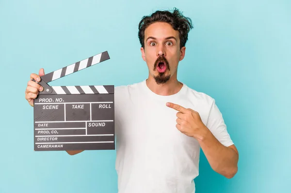 Giovane Uomo Caucasico Tenendo Clapperboard Isolato Sfondo Blu Che Punta — Foto Stock