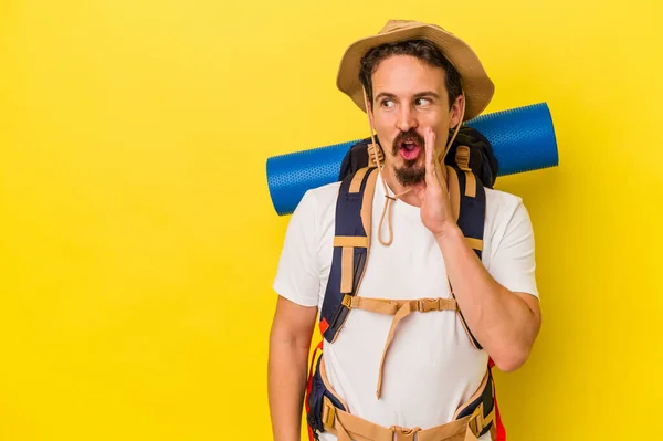 Jovem Caucasiano Caminhante Homem Isolado Fundo Amarelo Está Dizendo Segredo — Fotografia de Stock