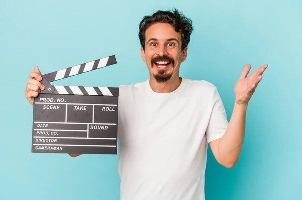 Joven Hombre Caucásico Sosteniendo Clapperboard Aislado Sobre Fondo Azul Recibiendo —  Fotos de Stock