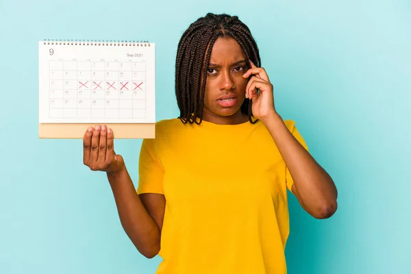 Ung Afrikansk Amerikansk Kvinna Håller Kalender Isolerad Blå Bakgrund Pekar — Stockfoto