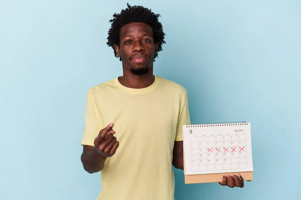 Jonge Afro Amerikaanse Man Met Kalender Geïsoleerd Blauwe Achtergrond Wijzend — Stockfoto