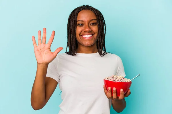 Ung Afroamerikansk Kvinna Håller Skål Med Spannmål Isolerad Blå Bakgrund — Stockfoto