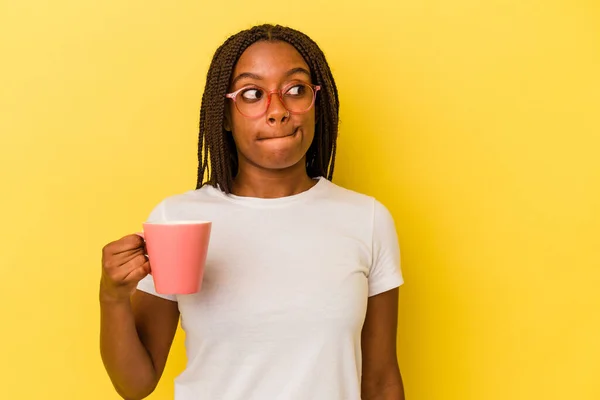 Mujer Afroamericana Joven Sosteniendo Una Taza Aislada Sobre Fondo Amarillo —  Fotos de Stock