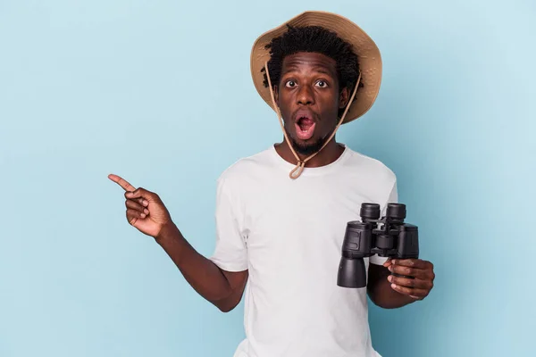 Young African American Man Holding Binoculars Isolated Blue Background Pointing — ストック写真