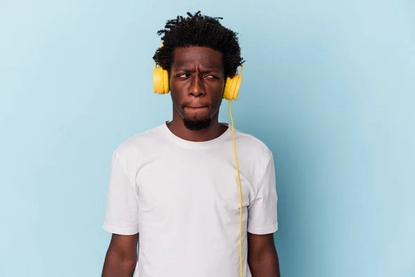 Jovem Afro Americano Ouvindo Música Isolada Fundo Azul Confuso Sente — Fotografia de Stock