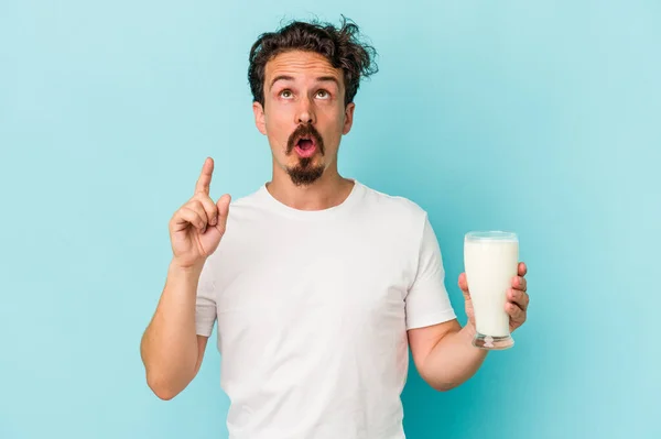 Joven Hombre Caucásico Sosteniendo Vaso Leche Aislado Sobre Fondo Azul — Foto de Stock