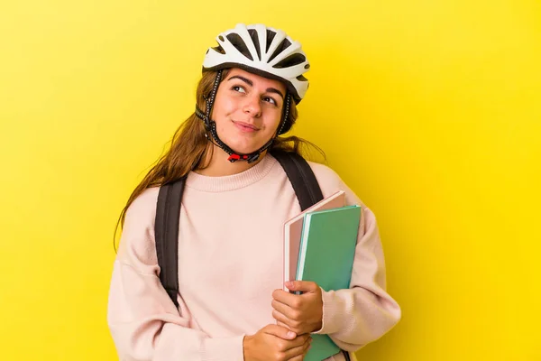若いです白人学生女性を身に着けています自転車ヘルメット黄色の背景夢の目標と目的を達成する — ストック写真