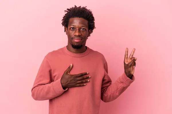 Joven Afroamericano Aislado Sobre Fondo Rosa Haciendo Juramento Poniendo Mano — Foto de Stock