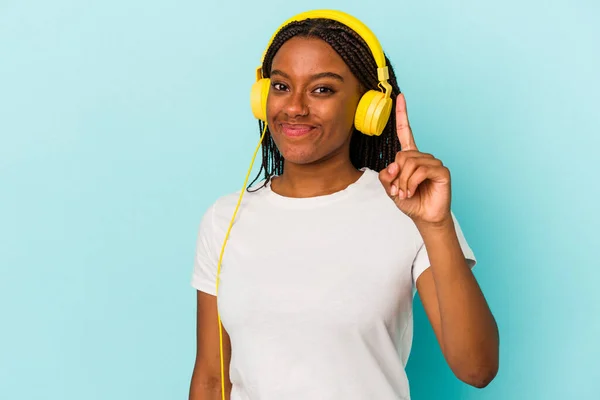 Junge Afroamerikanerin Hört Isoliert Musik Auf Blauem Hintergrund Und Zeigt — Stockfoto