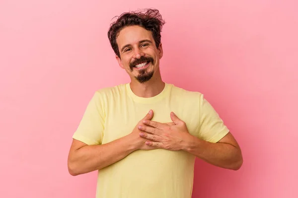 年轻的高加索男子被隔离在粉红色的背景上 有友好的表达 把手掌压在胸前 爱情的概念 — 图库照片
