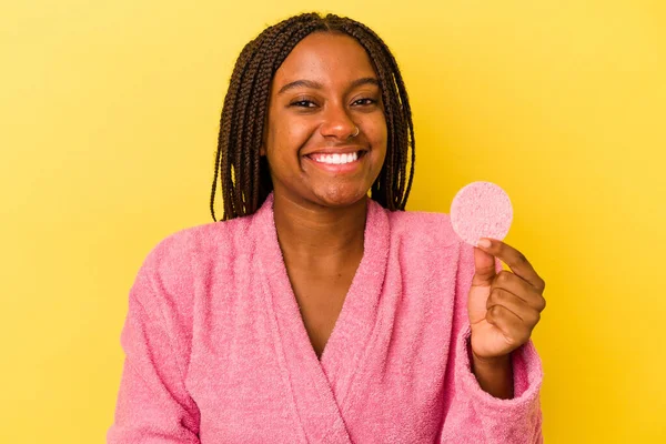 身穿浴衣的年轻的非洲裔美国女人拿着一个用黄色背景隔开的化妆盘 笑着玩得开心 — 图库照片