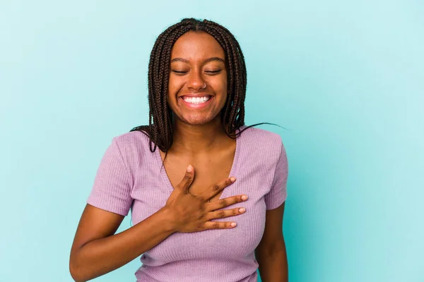 青を背景に孤立した若いアフリカ系アメリカ人女性が大声で手を胸に保ち笑い — ストック写真