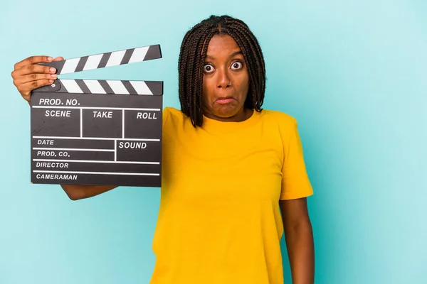 Ung Afrikansk Amerikansk Kvinna Håller Clapperboard Isolerad Blå Bakgrund Axelryckningar — Stockfoto