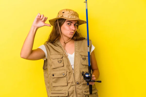 年轻的高加索女渔民拿着一根黄色背景的钓竿 感到自豪和自信 可以学习 — 图库照片