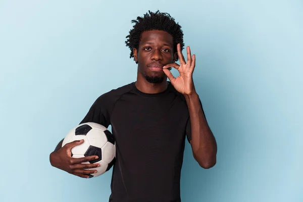 Młody Afroamerykanin Gra Piłkę Nożną Niebieskim Tle Palcami Ustach Trzymając — Zdjęcie stockowe