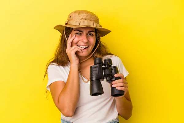 Junge Kaukasische Frau Mit Fernglas Isoliert Auf Gelbem Hintergrund Beißt — Stockfoto