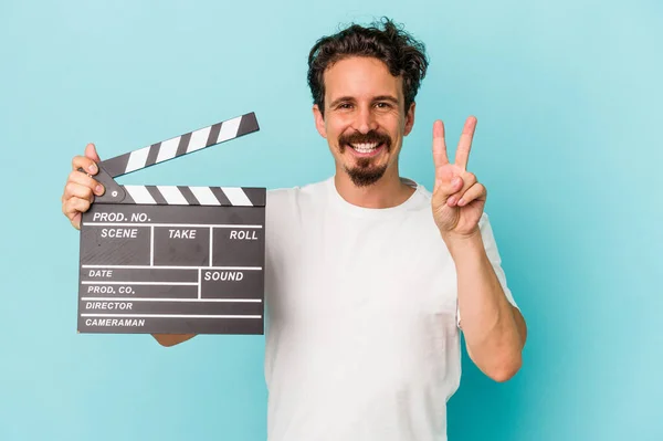 Ung Kaukasisk Man Håller Clapperboard Isolerad Blå Bakgrund Visar Nummer — Stockfoto