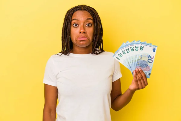 Mladá Africká Američanka Drží Bankovky Izolované Žlutém Pozadí Pokrčí Rameny — Stock fotografie