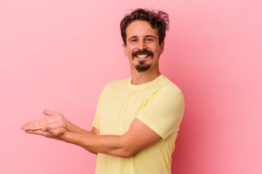 Pembe arka planda izole edilmiş beyaz bir adam elinde bir fotokopi odası tutuyor..