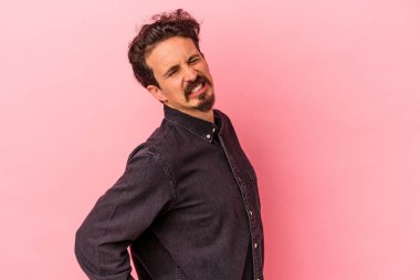 Pembe arka planda izole edilmiş beyaz bir adam sırt ağrısı çekiyor..