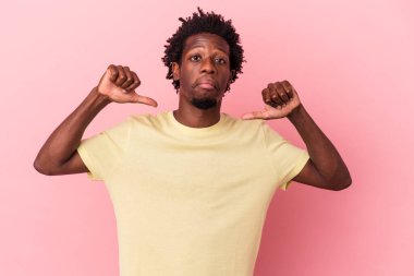 Pembe arka planda izole edilmiş genç bir Afrikalı Amerikalı gururlu ve kendinden emin, örnek olarak....