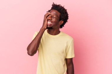 Genç Afro-Amerikan erkeği pembe arka planda izole edilmiş gülerek, kaygısız, doğal duygularla..