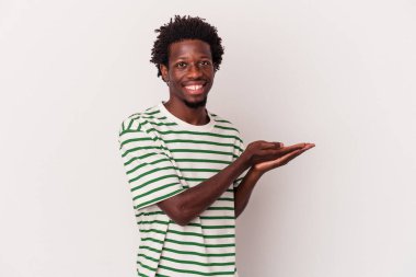 Beyaz arka planda izole edilmiş genç Afro-Amerikalı bir adam bir palmiye üzerinde bir kopya alanı tutuyor..