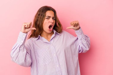 Pembe arka planda izole genç beyaz kadın gururlu ve kendinden emin hissediyor, örnek olarak..