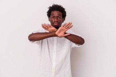 Beyaz arka planda izole edilmiş genç Afrikalı Amerikalı bir adam inkar jesti yapıyor.