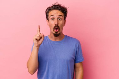 Pembe arka planda izole edilmiş beyaz bir adam ağzı açık bir şekilde üst tarafı işaret ediyor..