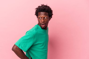 Genç Afrikalı Amerikalı bir adam pembe arka planda izole edilmiş gülümseyen, neşeli ve keyifli görünüyor..