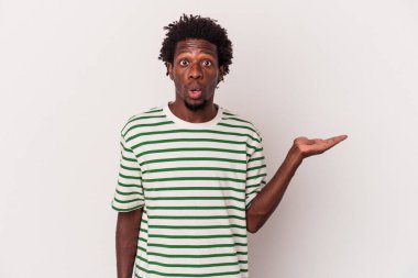 Beyaz arka planda izole edilmiş genç Afro-Amerikalı adam, avuç içi fotokopi alanı tutmaktan etkilenmiş..