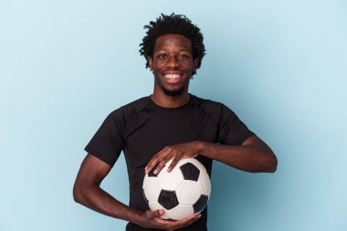 Genç Afro-Amerikan futbol oynayan adam mavi arka planda izole edilmiş.